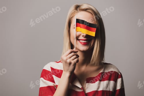 Preview: beatiful girl holds German flag on gray background
