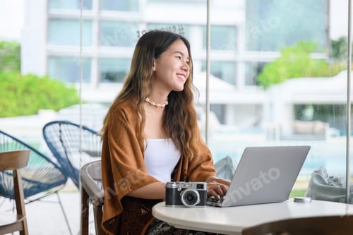 Vista previa: Mujer asiática usando cámara digital y computadora portátil en cafetería