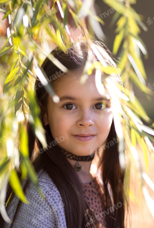 Preview: Portrait of a young beautiful brunette little girl outdoor in summer day.