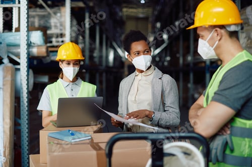 Preview: African American female supervisor communicating with workers at warehouse during COVID-19 pandemic.
