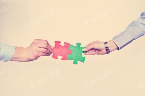 Preview: Group of business people assembling jigsaw puzzle