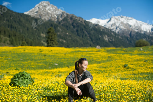 Preview: Young girl resting on a yellow mountain slope