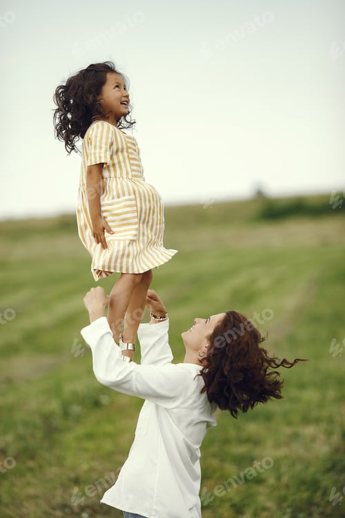 Preview: Mother with daughter playing in a summer field