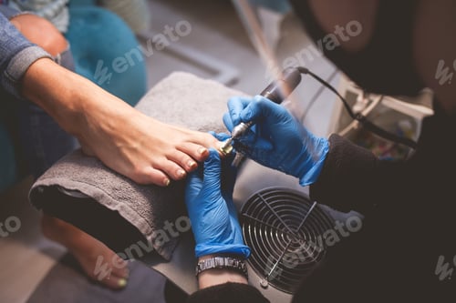 Preview: Pedicure master polishes nails before applying varnish