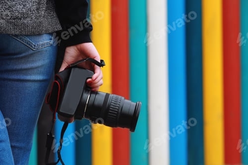 Preview: photographer holding camera, close-up. Back view, Selective focus