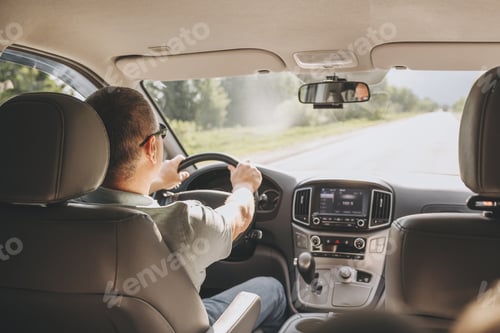Preview: Young man holding steering wheel while driving car. Road trip adventure