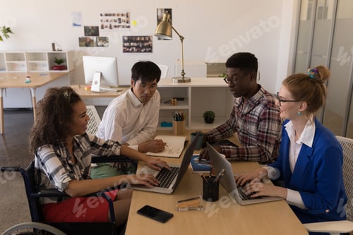 Preview: Side view of young diverse business executives interacting with each other in modern office