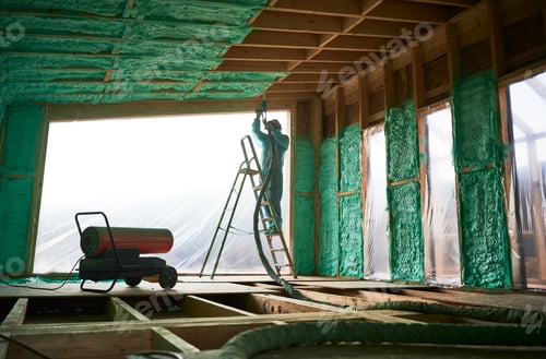 Preview: Worker spraying polyurethane foam for insulating wooden frame house.