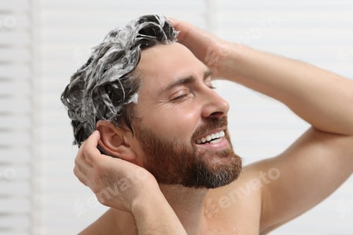 Preview: Happy man washing his hair with shampoo in shower