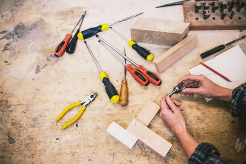 Preview: Hands of young craftswoman holding component in pipe organ workshop