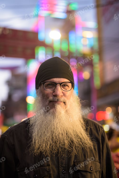 Preview: Mature bearded tourist man with eyeglasses in Chinatown at night