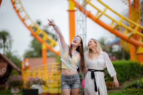 Preview: young woman having fun and happy smiling together at amusement theme park outdoor