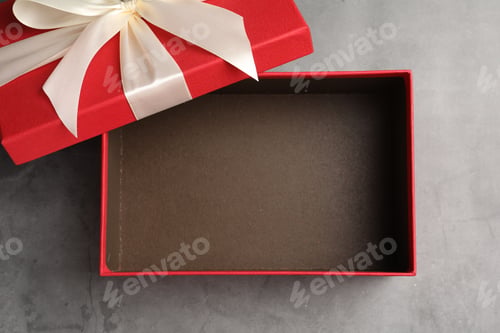 Preview: Opened gift box with beautiful lid on grey table, top view