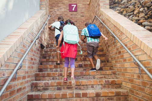 Preview: Three school kids climbing brick stairs