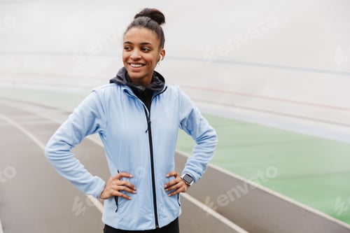 Preview: Attractive young healthy african sportswoman listening to music
