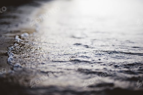 Preview: Closeup shot of sea waves coming up to the shore with blurred background