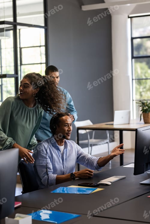 Preview: Collaborating in modern office, team discussing project using computer and headset