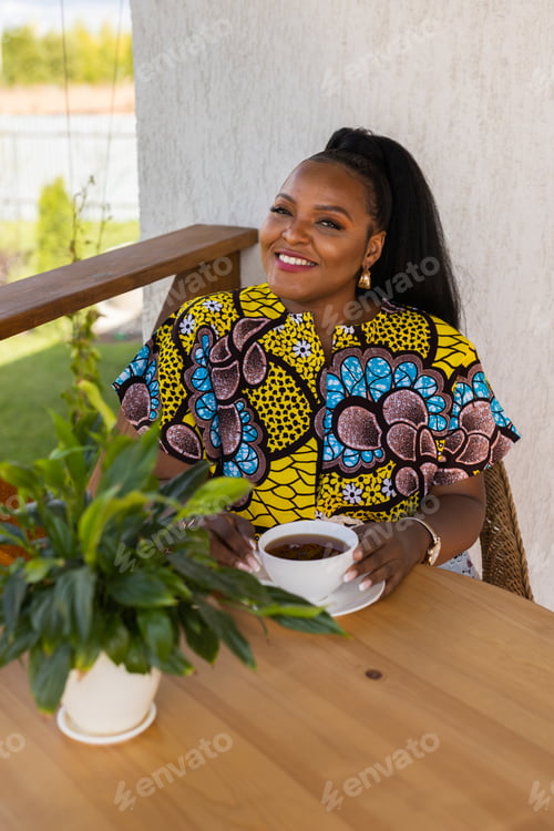 Preview: African american woman drinking tea on cozy balcony or terrace wooden country house in weekend on