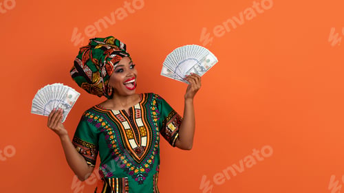 Preview: Excited african lady in traditional costume freelancer hold money