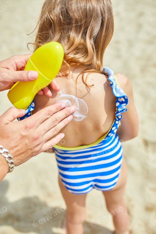 Preview: Dad applying sunscreem to daughter on the beach