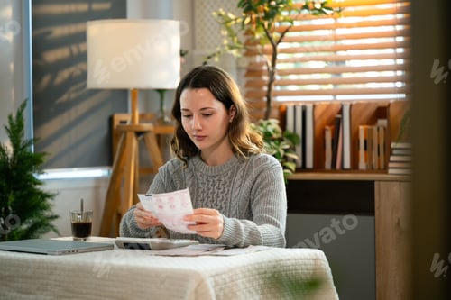 Preview: Stressed woman calculates bills and expenses in living room