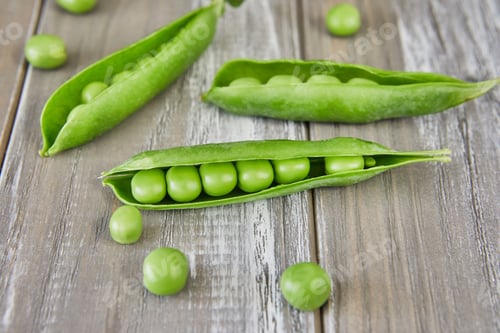Preview: Opened pods of fresh green peas on wooden background