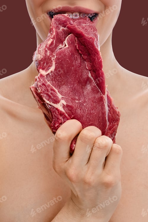 Preview: Teeth with dental braces bite raw meat