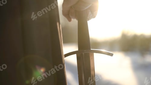 Preview: Man in medieval suit holding sword. Action. Close-up of man's hand in medieval suit holding sword