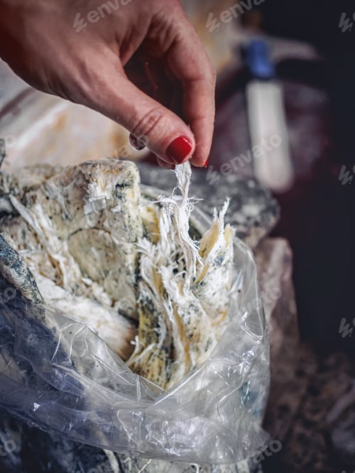 Preview: cropped shot of woman tearing homemade molded chechil cheese