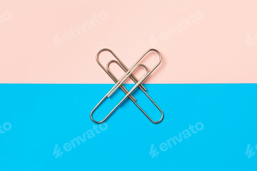 Preview: metal paper clips and paper on paper background