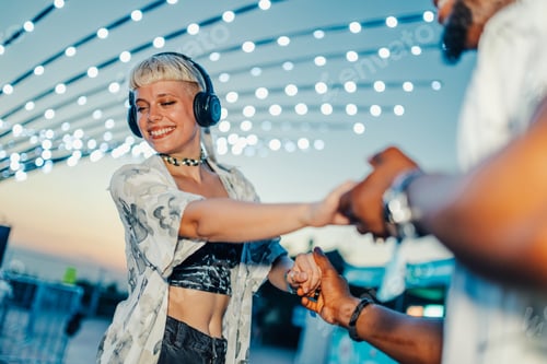Preview: Young couple dancing and holding hands at music festival