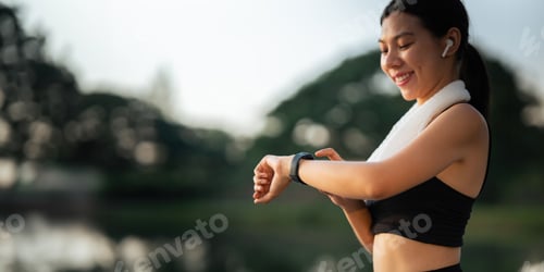 Preview: Portrait of smiling Asian woman looking at her smartphone and watch, standing in park wearing sport