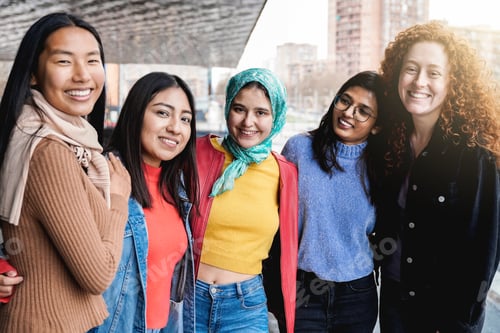 Preview: Diverse female friends having fun togehter on city street. Group of multiracial people smiling