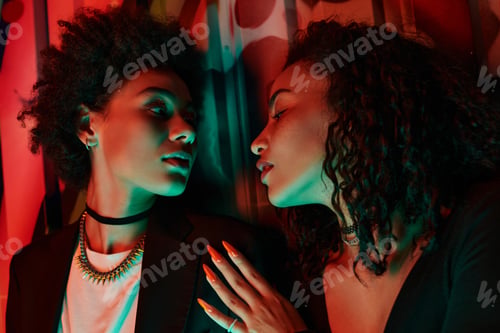 Preview: Intimate portrait of two women sharing a moment of connection amid vibrant colors and textures