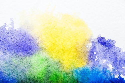 Preview: top view of blue, yellow, purple and green watercolor spills on white background