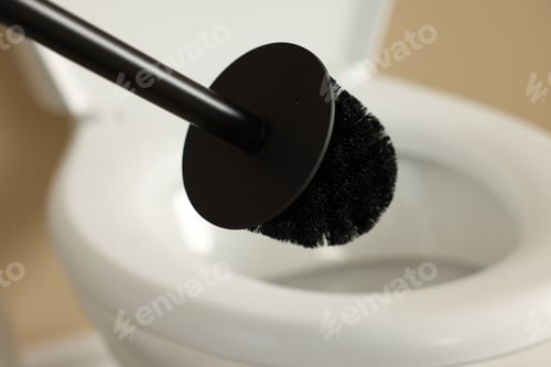 Preview: Cleaning toilet bowl with black brush indoors, closeup