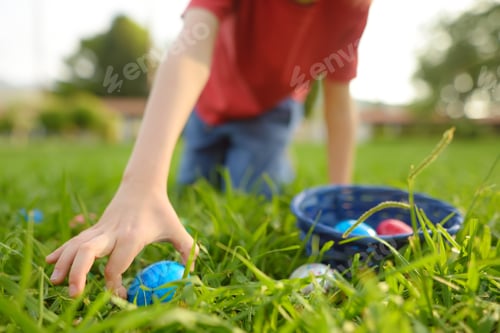 Preview: Little boy hunting for eggs in spring garden on Easter day. Focus on hand.