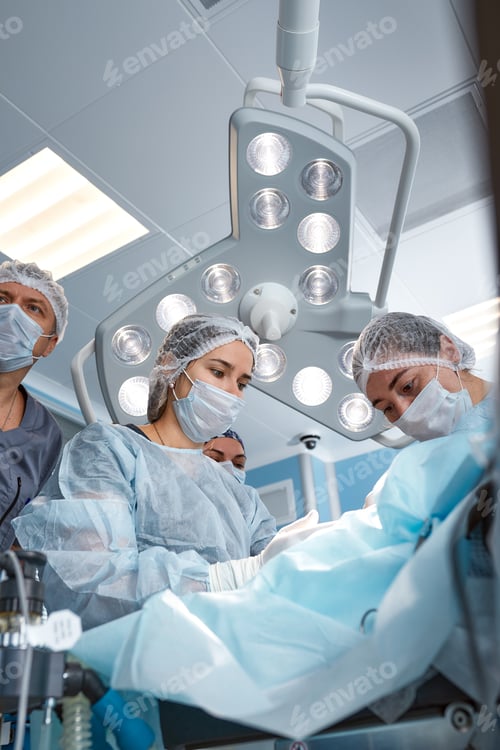 Preview: Concentrated Surgical team operating a patient in an operation theater. Well-trained