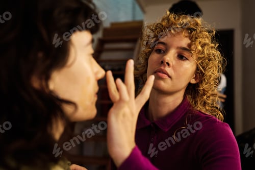 Preview: Makeup artist applying foundation on model's face in professional setting
