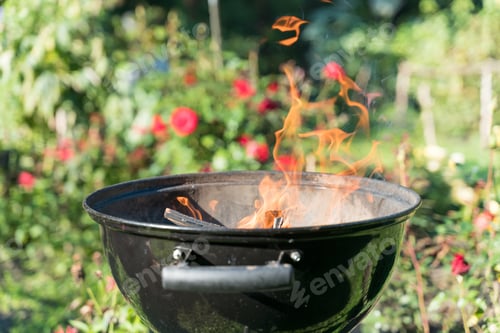 Barbecue Grill with Flames in a Lush Garden