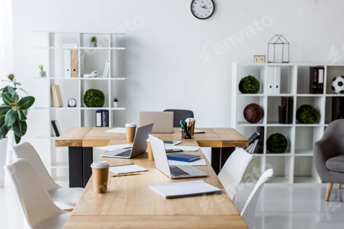 Preview: interior of modern business office with laptops on table, chairs and furniture