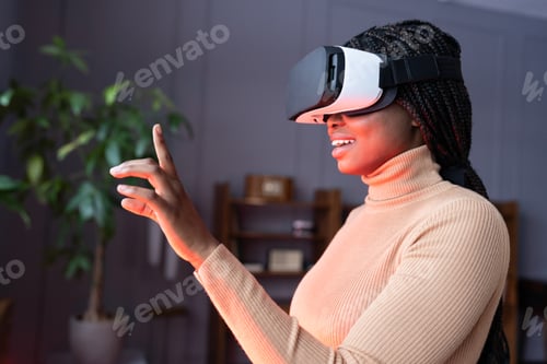 Preview: Excited afro woman enjoying shopping in virtual reality, raising hand up with mouth slightly opened