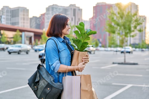 Preview: Urban portrait of middle aged woman with shopping bags in mall parking