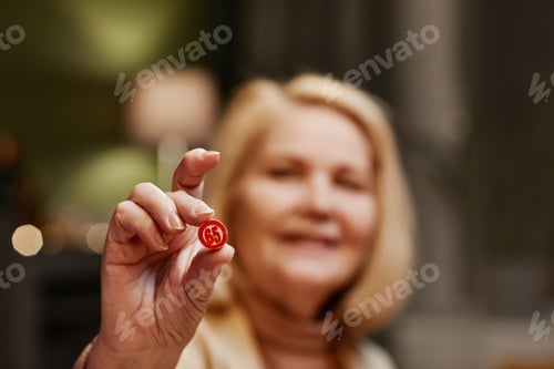Preview: Aged woman holding dice number in hand