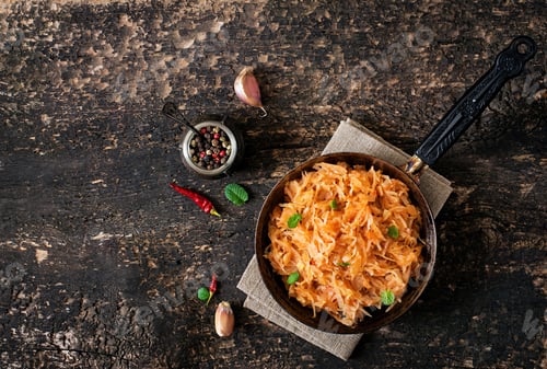 Preview: Stewed cabbage on the old wooden background in rustic style. Top view