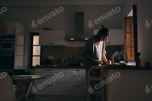 Preview: Woman cutting fruits while cooking in kitchen