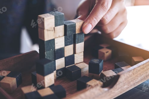 Preview: Closeup image of people playing and building wooden puzzle game