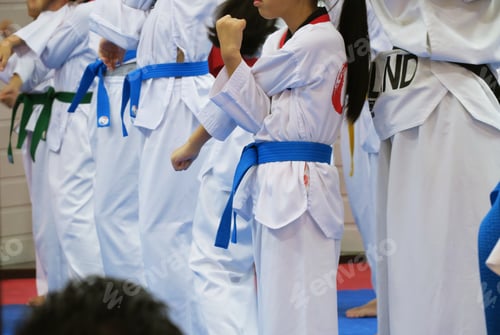 Preview: Group of Taekwondo students wearing white uniforms standing practice in class closeup background