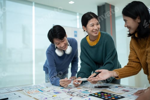 Preview: Asian team ux developer and ui designer brainstorming about mobile app interface wireframe design o