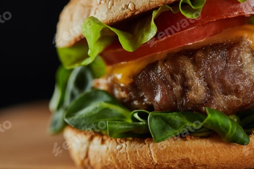 Preview: close up of tasty meat burger with cheese, greenery and tomatoes